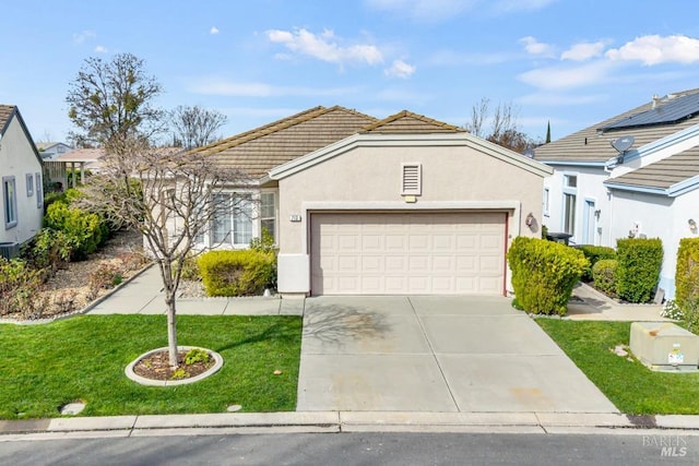 view of front of home featuring driveway, a front lawn, an attached garage, and stucco siding