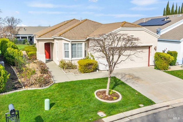 ranch-style home featuring a front lawn, concrete driveway, and stucco siding