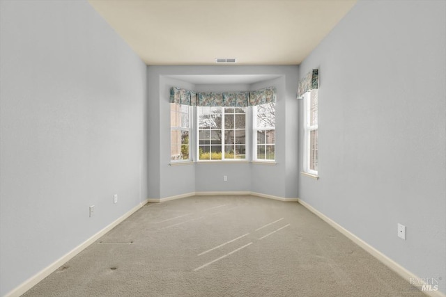 carpeted empty room with baseboards and visible vents