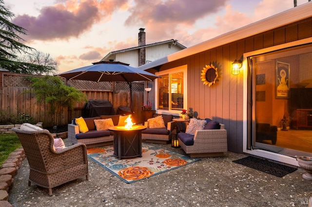 view of patio featuring an outdoor living space with a fire pit and fence