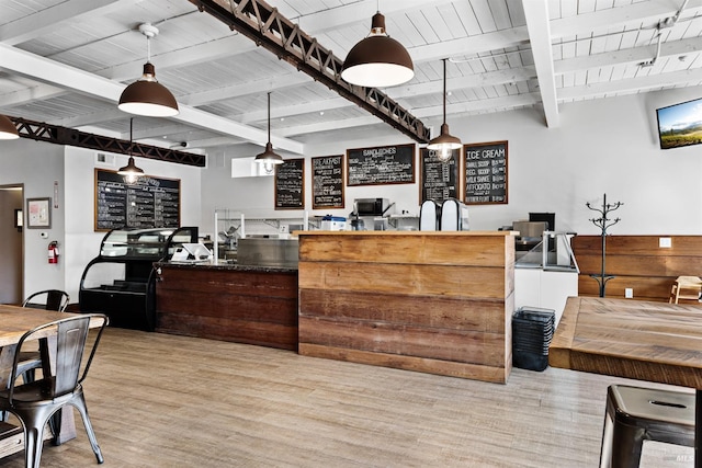 interior space with hanging light fixtures, beam ceiling, wooden ceiling, and light wood finished floors