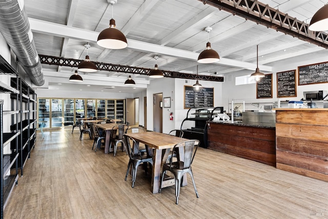 dining room featuring beamed ceiling and wood finished floors