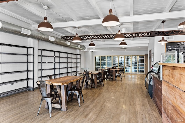 dining space featuring beam ceiling, wood finished floors, and visible vents