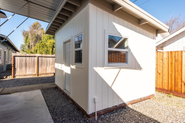 view of side of home with a fenced backyard and an outdoor structure