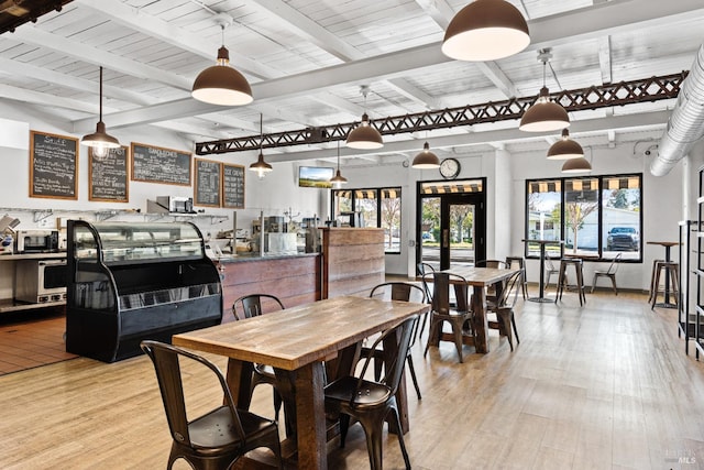 dining area with light wood-type flooring, beam ceiling, and wooden ceiling