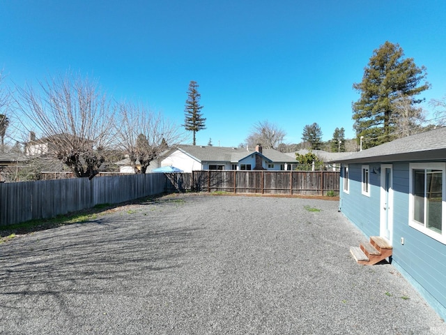 view of yard with entry steps and a fenced backyard