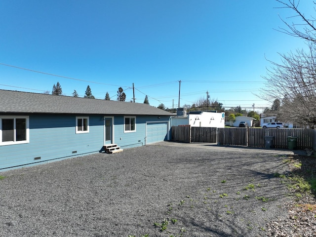 view of front facade with crawl space, entry steps, driveway, and fence