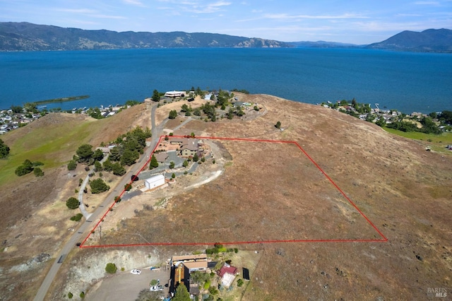 drone / aerial view featuring a water and mountain view