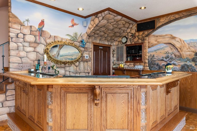 bar featuring bar, ornamental molding, and a textured ceiling