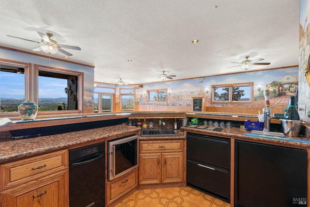 kitchen with brown cabinetry, a sink, a textured ceiling, and light floors