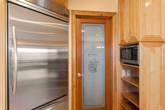 interior space with light brown cabinetry and appliances with stainless steel finishes