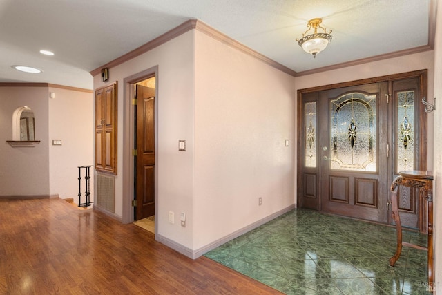 foyer featuring ornamental molding, recessed lighting, wood finished floors, and baseboards