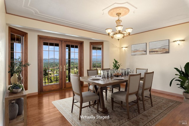 dining space featuring crown molding, wood finished floors, and french doors