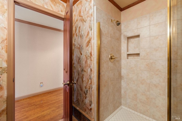 bathroom featuring wood finished floors, ornamental molding, and a shower stall