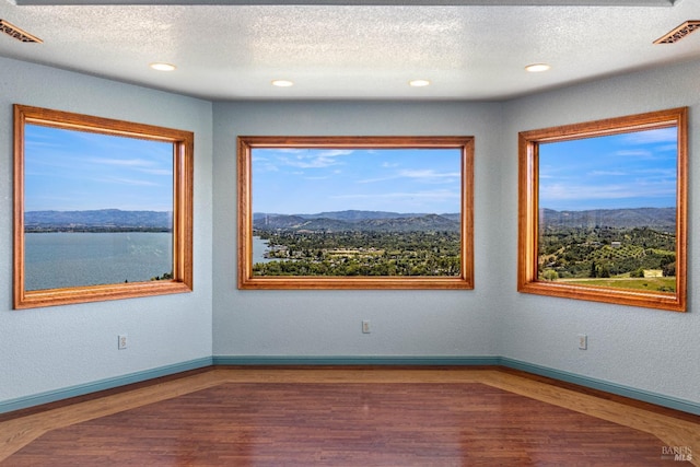 unfurnished room with a healthy amount of sunlight and visible vents