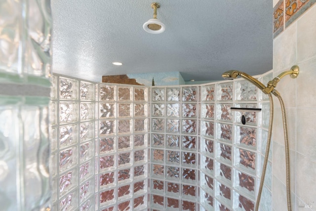 bathroom with a textured ceiling and walk in shower