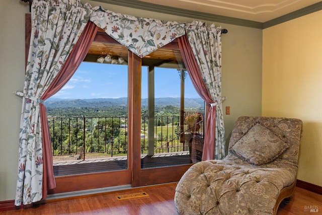 sitting room with crown molding, visible vents, a mountain view, and wood finished floors