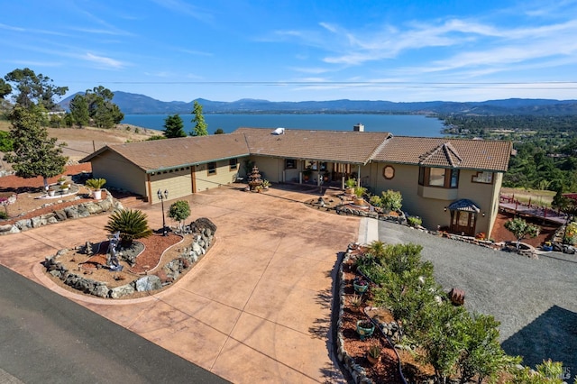 ranch-style home featuring driveway, a tiled roof, and a mountain view