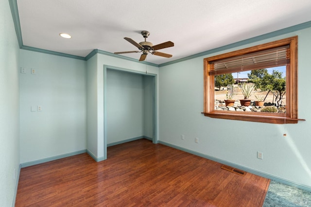 unfurnished bedroom featuring a closet, visible vents, crown molding, and wood finished floors