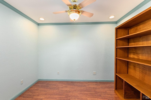 spare room with a ceiling fan, ornamental molding, baseboards, and wood finished floors