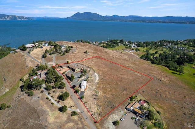 birds eye view of property with a water and mountain view