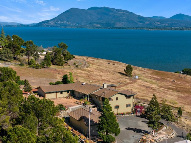 drone / aerial view featuring a water and mountain view