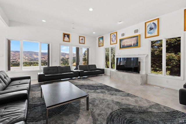 living room featuring tile patterned flooring, recessed lighting, a premium fireplace, visible vents, and french doors