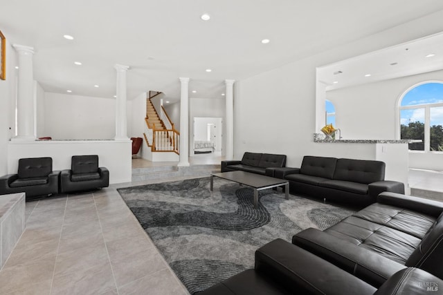 living area with ornate columns, stairs, light tile patterned floors, and recessed lighting