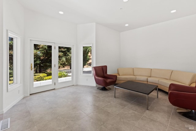 living room with baseboards, plenty of natural light, visible vents, and recessed lighting