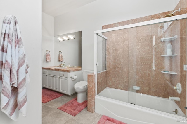 full bath featuring enclosed tub / shower combo, vanity, toilet, and tile patterned floors