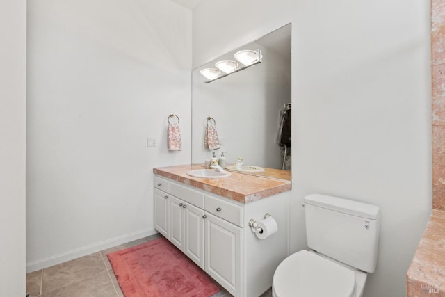 bathroom featuring toilet, tile patterned floors, baseboards, and vanity