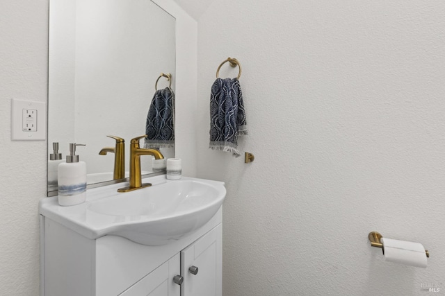 bathroom with a textured wall and vanity