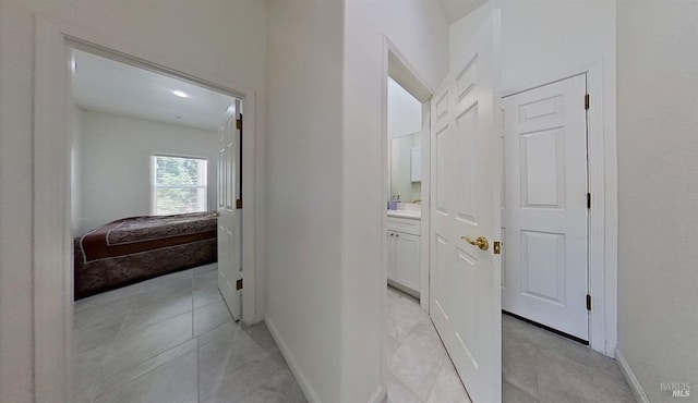 hallway with baseboards and light tile patterned floors