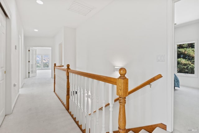 hallway featuring recessed lighting, visible vents, carpet flooring, and an upstairs landing