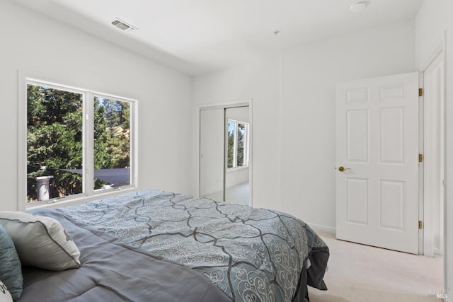 bedroom featuring light carpet, a closet, and visible vents