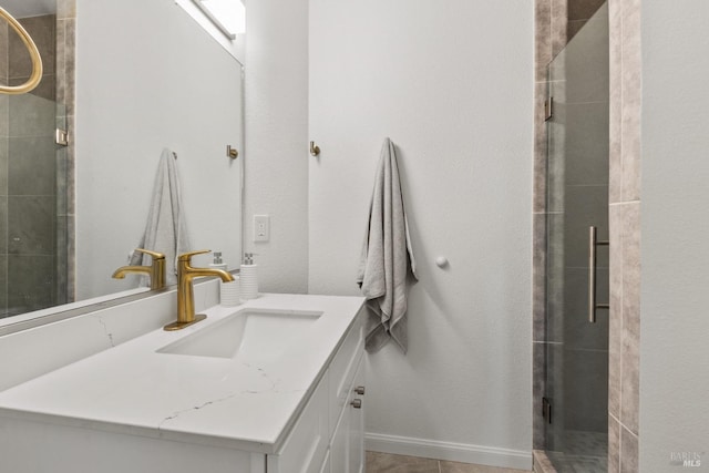 full bath featuring a shower stall, vanity, and baseboards