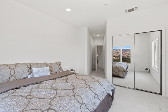 bedroom featuring a closet, light colored carpet, visible vents, and recessed lighting