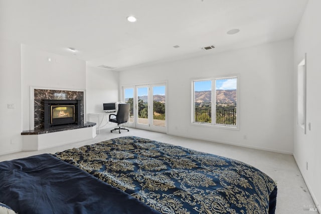 bedroom featuring visible vents, baseboards, access to outside, carpet floors, and a high end fireplace