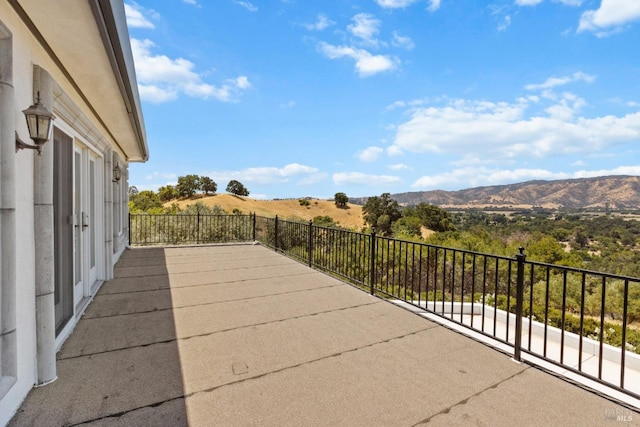 view of patio featuring a mountain view and a balcony