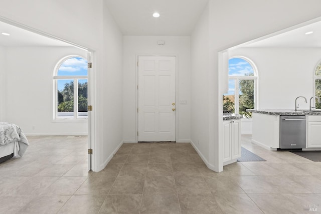 entryway featuring baseboards, light tile patterned floors, recessed lighting, and a healthy amount of sunlight