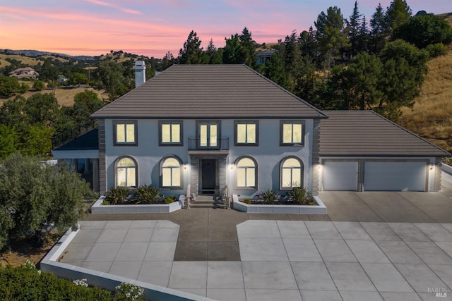 view of front of property with a garage, concrete driveway, a tiled roof, and stucco siding