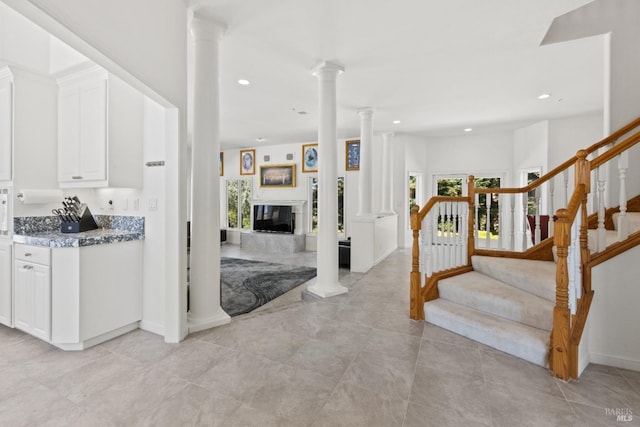 entrance foyer with ornate columns, stairs, a fireplace, and recessed lighting