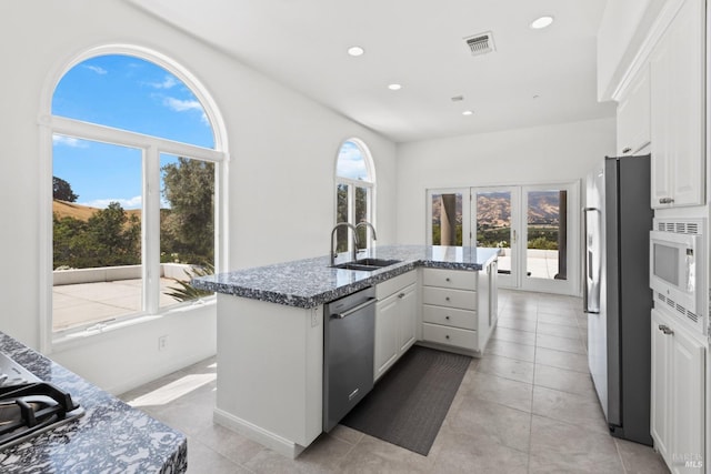 kitchen with appliances with stainless steel finishes, visible vents, a sink, and white cabinetry