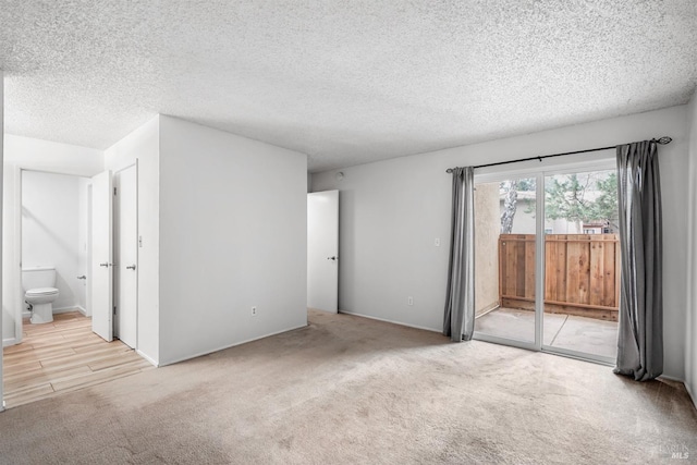 unfurnished room featuring carpet and a textured ceiling