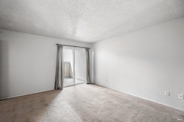 carpeted empty room featuring a textured ceiling