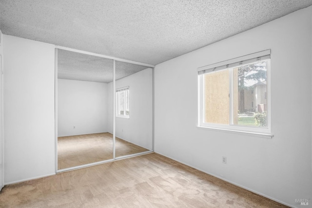 unfurnished bedroom featuring carpet, a closet, and a textured ceiling