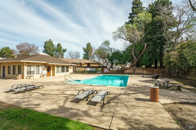 community pool featuring a fire pit, a patio, and a fenced backyard