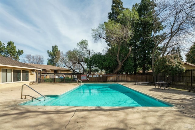 community pool with fence and a patio