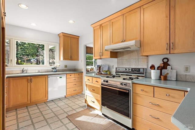 kitchen featuring dishwasher, white gas stove, under cabinet range hood, a sink, and recessed lighting