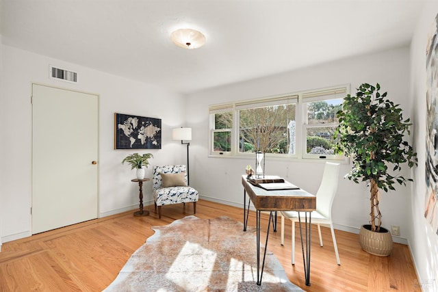 sitting room with light wood-style floors, baseboards, and visible vents